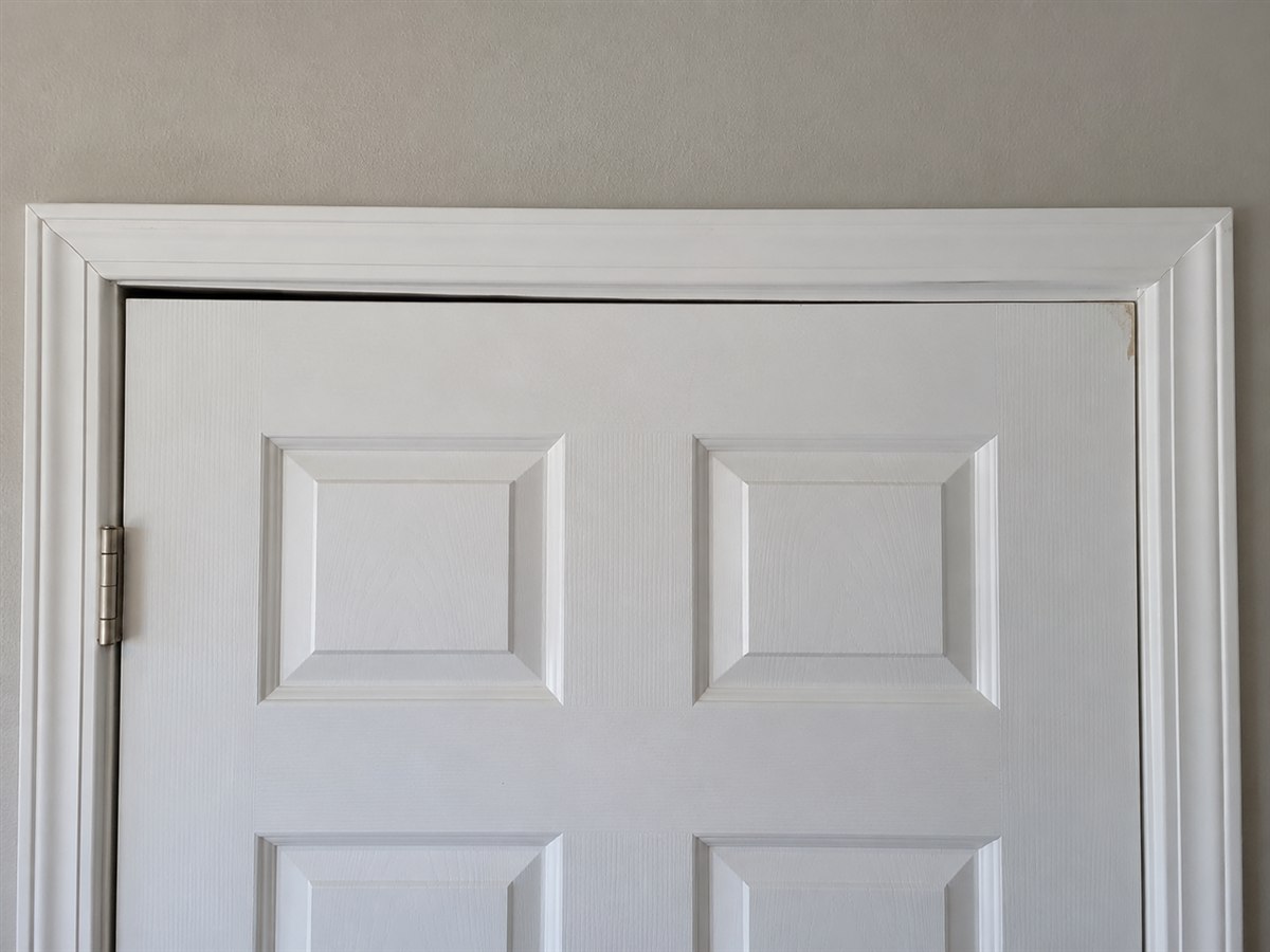 Interior door out of square in its frame, with an uneven gap along the top